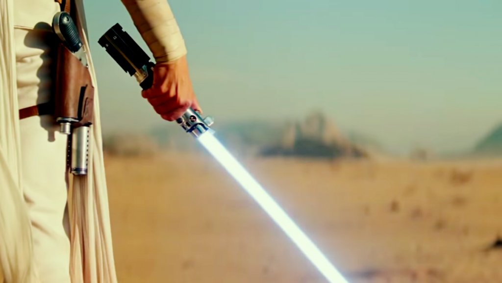 Lightsaber History. Rey holding a lighsaber